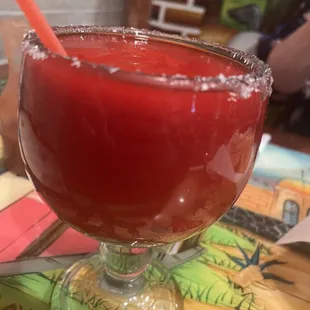 a red drink in a glass with a straw