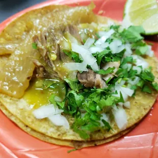 a taco with meat and vegetables on a plate
