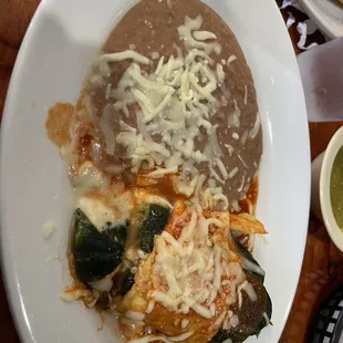 a plate of enchiladas and a bowl of salsa