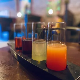 a row of different drinks on a tray