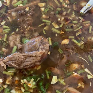 a bowl of soup with meat and vegetables