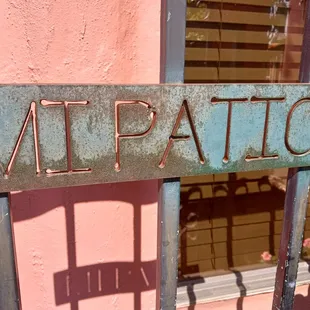 Mi patio sign engraved into the entrance gate, swimmingly enough, on the patio.