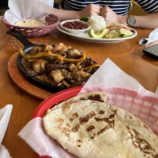 a woman sitting at a table with plates of food