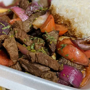 Lomo Saltado ($15.99) - Peruvian-style beef stir-fry mixed with onions, tomatoes, cilantro, soy sauce, and served on fries and jasmine rice.