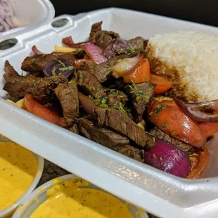 Lomo Saltado ($15.99) - Peruvian-style beef stir-fry mixed with onions, tomatoes, cilantro, soy sauce, and served on fries and jasmine rice.