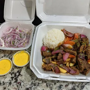 Lomo Saltado ($15.99) - Peruvian-style beef stir-fry mixed with onions, tomatoes, cilantro, soy sauce, and served on fries and jasmine rice.