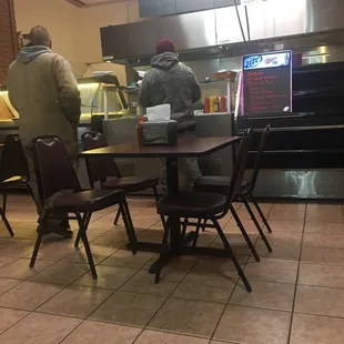 a man standing at a table in a restaurant