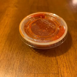 a plastic container with a sauce in it