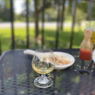 a glass of white wine and a plate of food