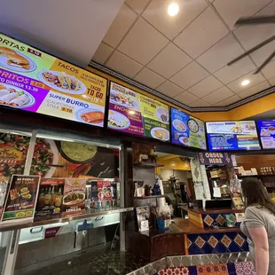 a woman standing in front of a menu