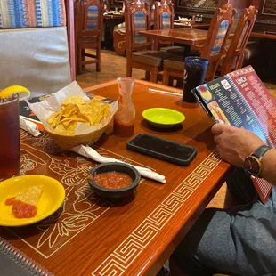 a man sitting at a table reading a book