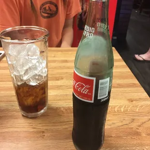 a bottle of coke and a glass of coke