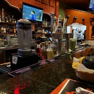 a bar with a blender and a television