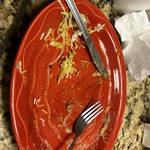 a red plate with a fork and knife