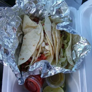 Al Pastor tacos with hot sauce and lime.