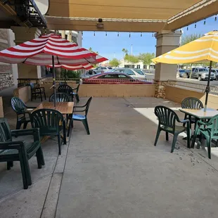 a patio with tables and umbrellas