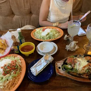 a woman sitting at a table with mexican food