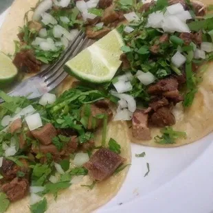 two tacos on a plate with a fork