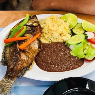 Fried tilapia with rice and beans and salad.