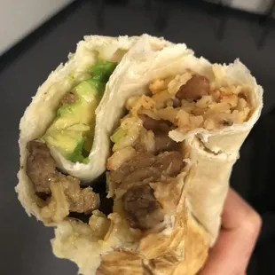 a hand holding a burrito