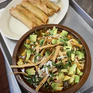 a bowl of mexican food and a plate of tortillas