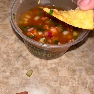  a person dipping a tortilla into a bowl