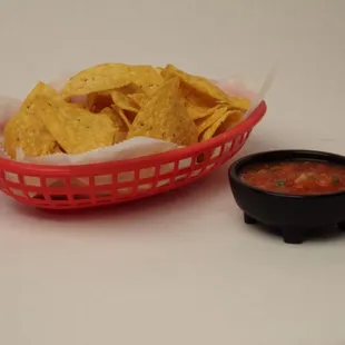 a basket of chips and a bowl of salsa