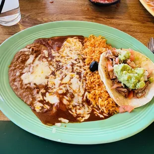 Beans, cheese enchiladas, Spanish rice, and a Carnitas soft taco combination plate.