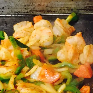 shrimp and vegetables cooking in a skillet
