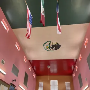 the interior of a school with flags hanging from the ceiling