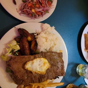 Ribeye, plantains, 1 egg, salad, encurtido, rice, fries, empanada and a Cristal beer.