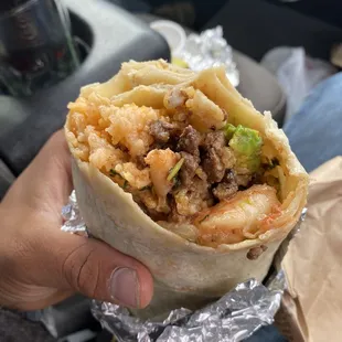 a hand holding a burrito