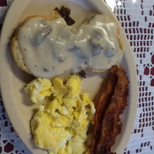 The biscuit and gravy plate with sausage and bacon and eggs added