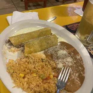 Shredded beef enchiladas with cheese sauce, rice and beans.