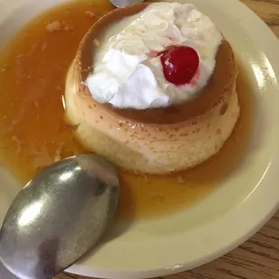 a plate of flan flan with a cherry on top