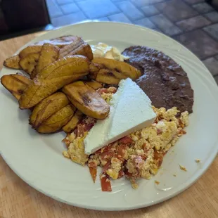 Huevos con tomate y plátano maduro.