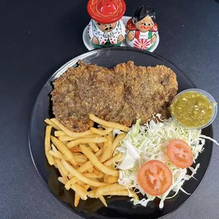 Milanesa- Breaded Beef served with French fries, lettuce and tomatoes.