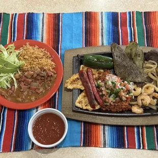 El Comal- Carne Asada, chicken, grilled nopales, sausage, jalapeño, shrimp &amp; onions. Topped w/ choriqueso &amp; pico. Rice, beans, lettuce.