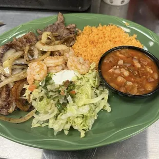 A la Veracruzana 2 Carne Asada w/ grilled onions and garlic shrimp. Served w/ rice, charro beans and lettuce, pico, sour cream and tortillas