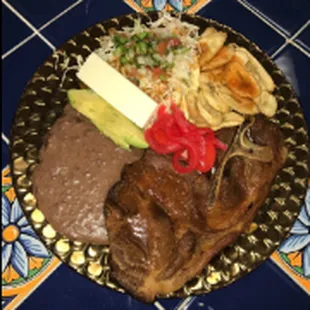 Chuleta frita especial con tajadas/Special Fried Pork Steak with fried green bananas, fried beans, avocado, and a slice of cheese