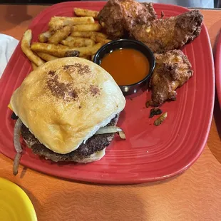 Burger with onions mushrooms fries, and wings