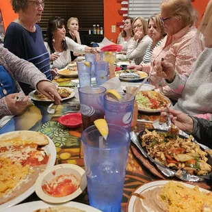 a group of people sitting around a table eating pizza