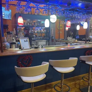a bar with white stools
