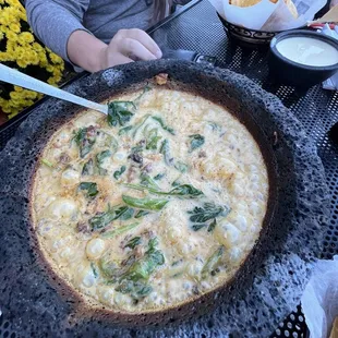 a woman cutting into a pizza