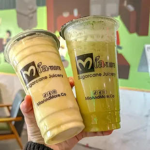 a hand holding two drinks