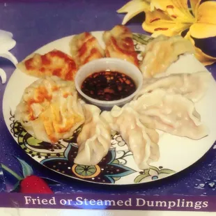 a plate of dumplings and dipping sauce