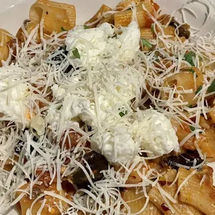 a plate of pasta with cheese and olives