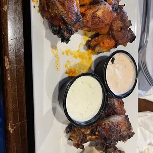 a plate of food with chicken and sauces