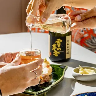 a person pouring tea into a glass