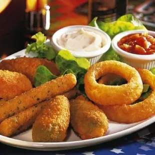 a plate of deep fried onion rings and dipping sauce